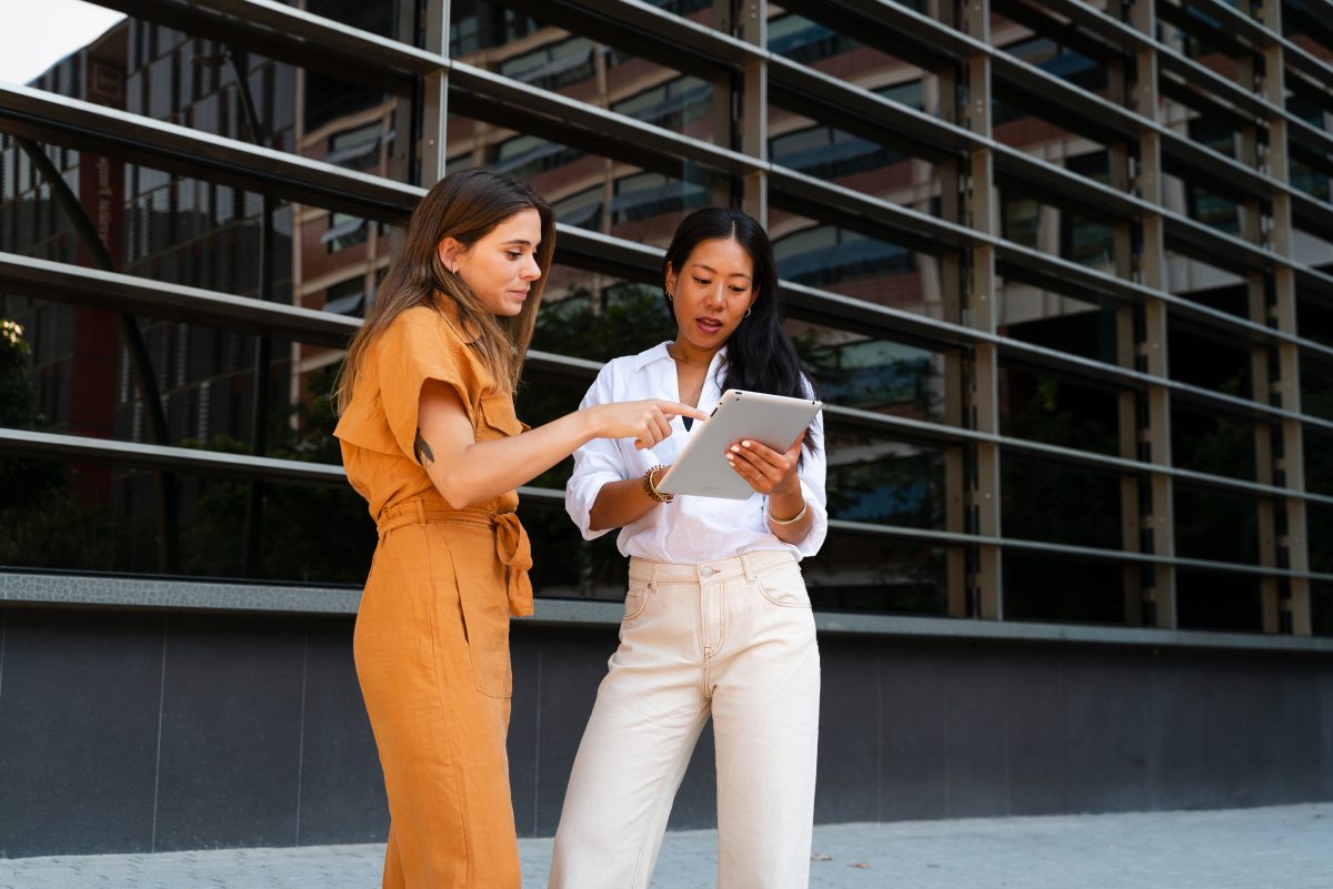 twee vrouwen bespreken iets op een tablet.