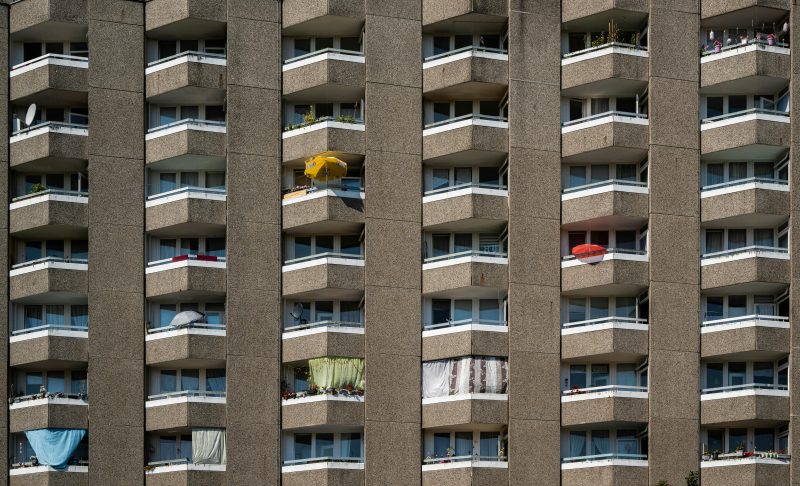 flatgebouw met balkons en kleurrijke parasols